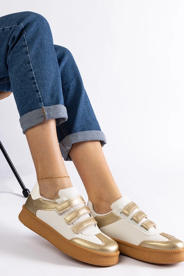 Goldene Sneakers mit...