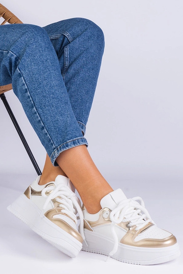 Weiß-goldene Sneakers auf...