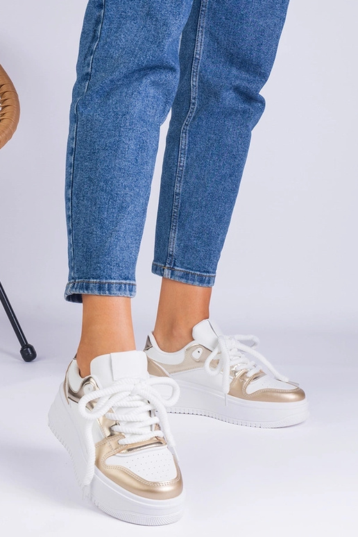 Wit-gouden sneakers op een platform...