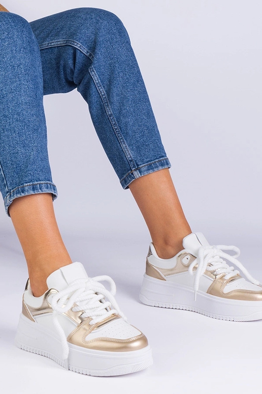 Wit-gouden sneakers op een platform...