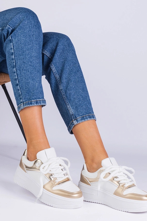 Wit-gouden sneakers op een platform...