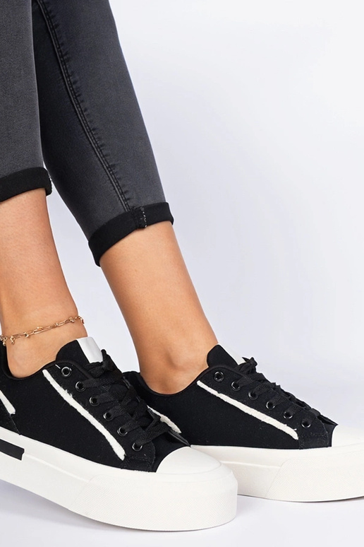 Zwarte damessneakers van stof op een...