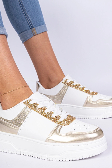Gouden damessneakers op een... 2