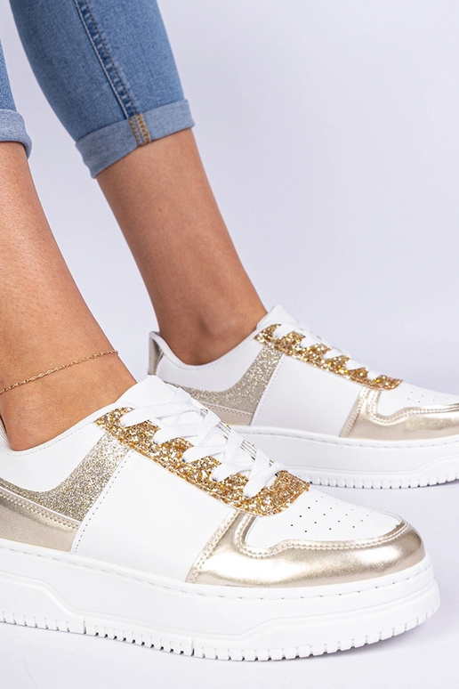 Gouden damessneakers op een dikke... Gouden damessneakers op een dikke...