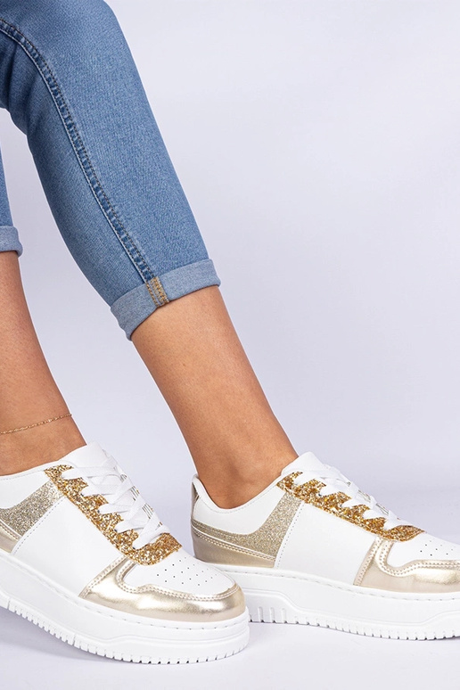 Gouden damessneakers op een dikke... Gouden damessneakers op een dikke...