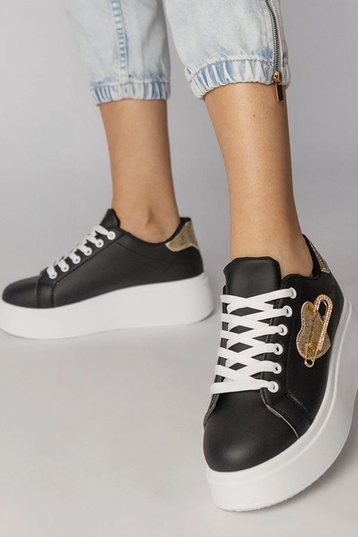 Schwarze Sportschuhe mit herzförmigem... Schwarze Sportschuhe mit herzförmigem...