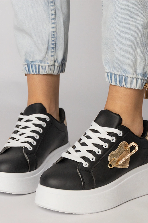 Schwarze Sportschuhe mit herzförmigem... Schwarze Sportschuhe mit herzförmigem...