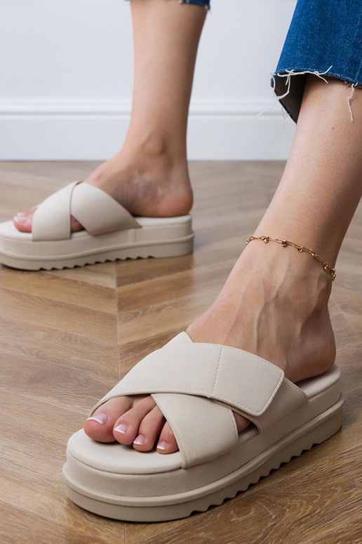 Zandkleurige slippers met bandjes op...