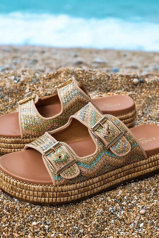 Gouden slippers met gespen aan de...