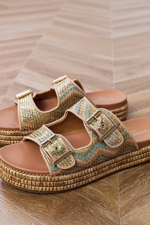 Gouden slippers met gespen aan de...