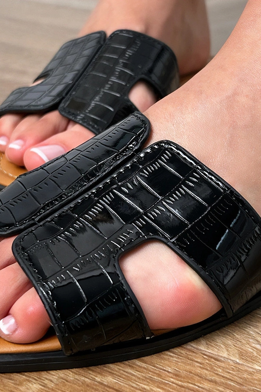 Zwarte slippers op vlakke zool met... Zwarte slippers op vlakke zool met...