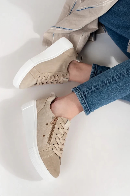 Zandkleurige sneakers model op een... Zandkleurige sneakers model op een...
