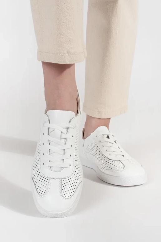 Witte sportschoenen geperforeerd van... Witte sportschoenen geperforeerd van...