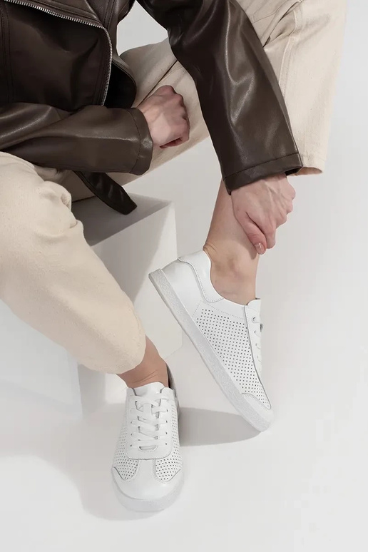 Witte sportschoenen geperforeerd van... Witte sportschoenen geperforeerd van...