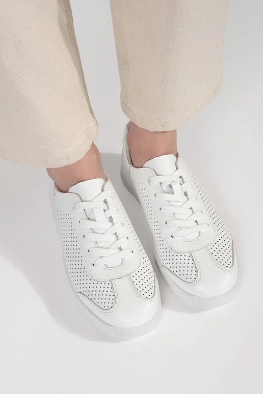 Witte sportschoenen geperforeerd van... Witte sportschoenen geperforeerd van...