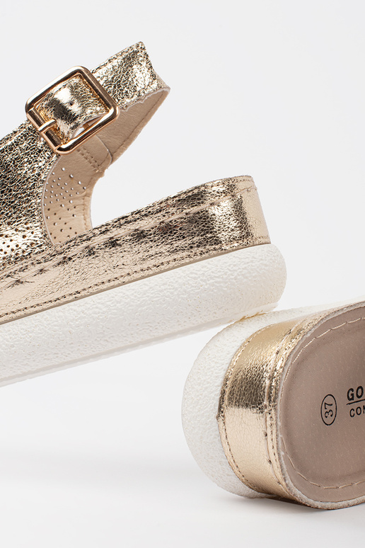 Gouden sandalen op een lichte plateau Gouden sandalen op een lichte plateau