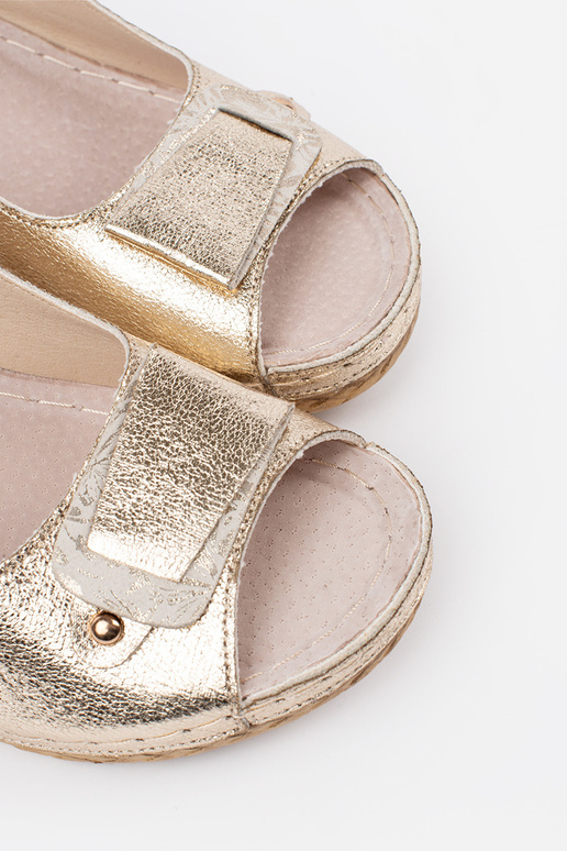 Gouden sandalen op een lage wig