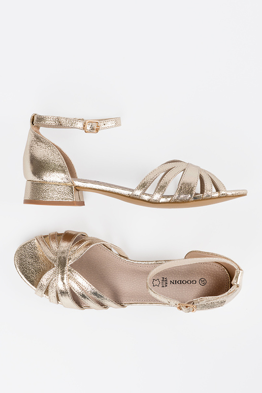 Elegante, goldene Sandalen auf...