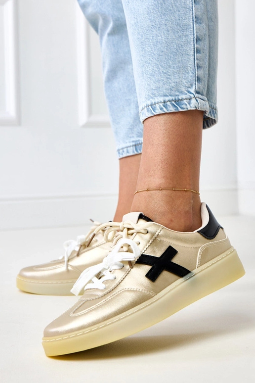 Goldene Sneakers auf Plattform mit... Goldene Sneakers auf Plattform mit...