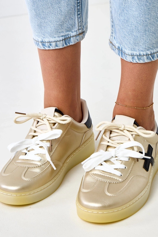 Goldene Sneakers auf Plattform mit... Goldene Sneakers auf Plattform mit...