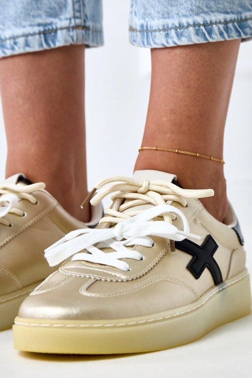 Goldene Sneakers auf Plattform mit... Goldene Sneakers auf Plattform mit...