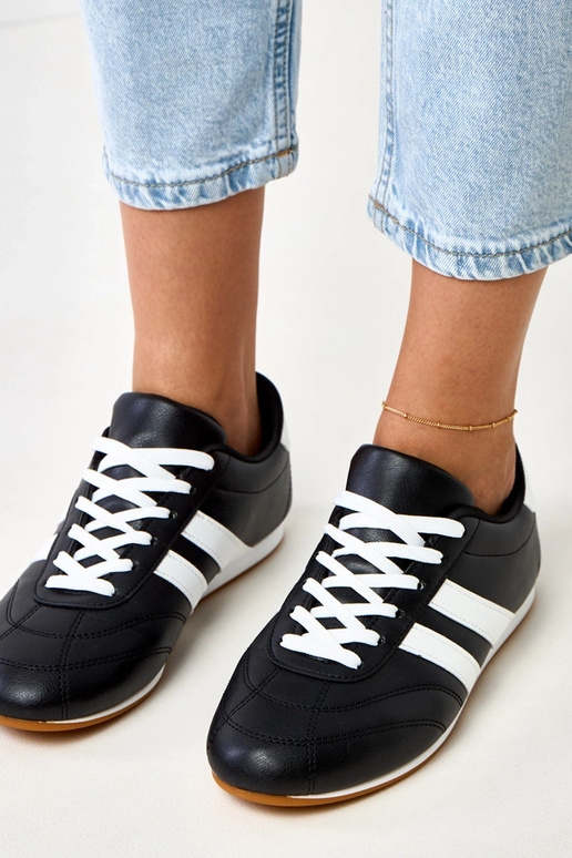 Schwarze Tennisschuhe mit weißem... Schwarze Tennisschuhe mit weißem...