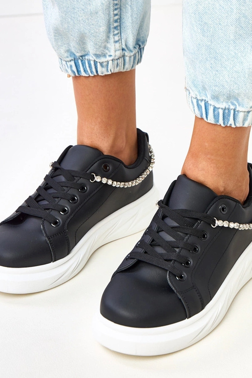 Zwarte sneakers op een platform met... Zwarte sneakers op een platform met...