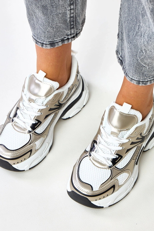 Gouden sportieve schoenen op een... Gouden sportieve schoenen op een...