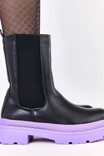 Zwarte laarzen op paarse...