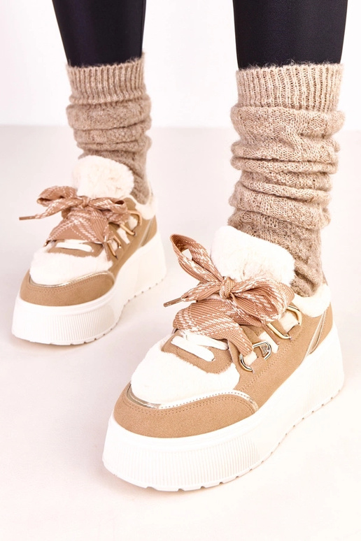Zandkleurige warme sneakers op een... Zandkleurige warme sneakers op een...