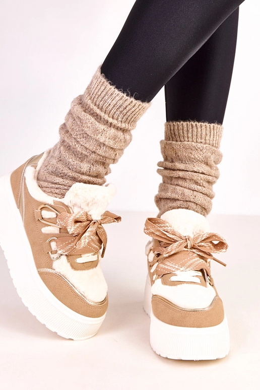 Zandkleurige warme sneakers op een... Zandkleurige warme sneakers op een...