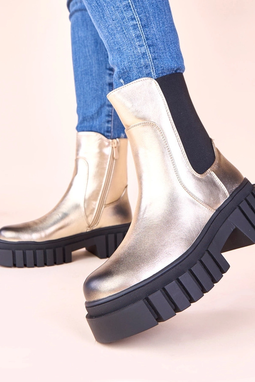 Gouden enkellaarsjes op een platform...