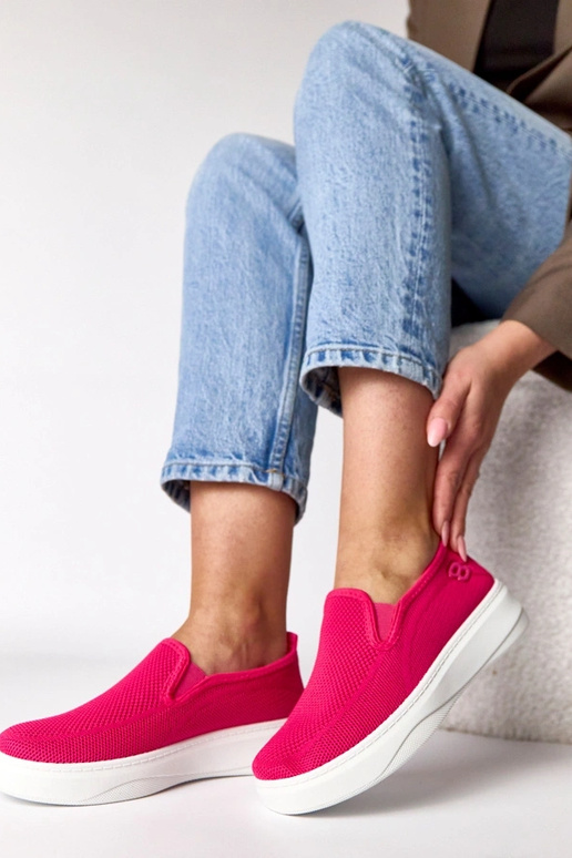 Roze stoffen sneakers op een platform...