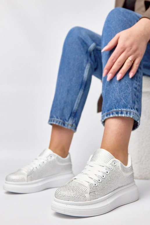 Witte sneakers op een platform...