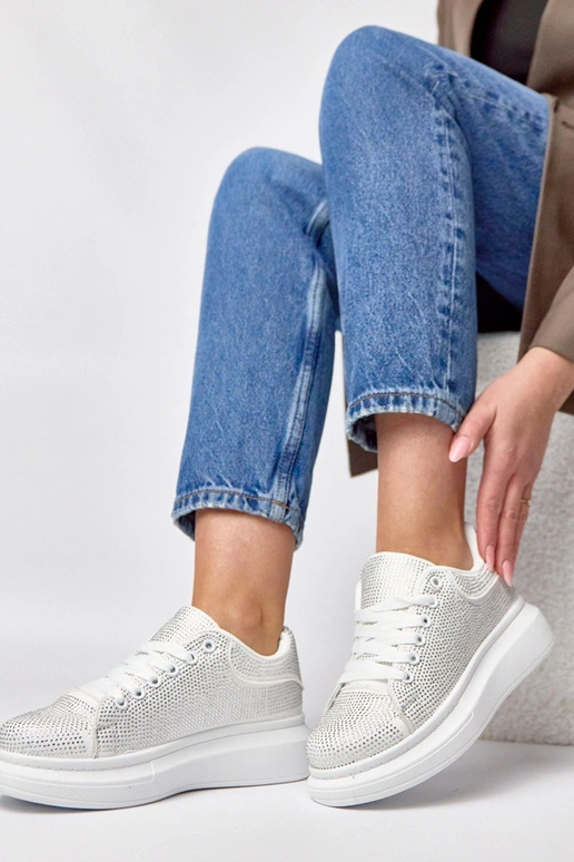 Witte sneakers op een platform...